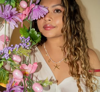 a woman in a white blouse and a flower arrangement