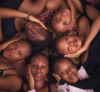 A group of Black women lying in a circle, symbolizing sisterhood, empowerment, and unity.
