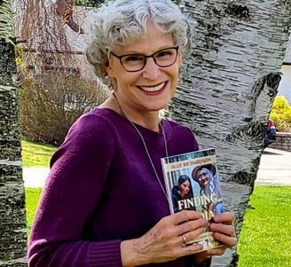 Allie Richardson author of Finding Lydia in a purple sweater holding her book