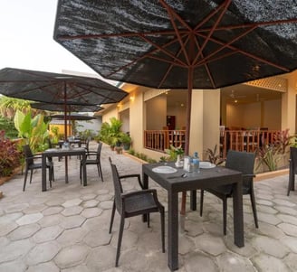 a patio with a table and chairs and umbrellas
