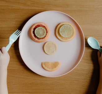 a child's face made of fruit on a plate