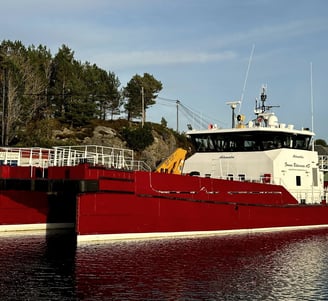 a large red boat is docked at a dock