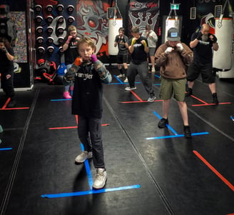 a group of beginner boxers lined up, shadow boxing