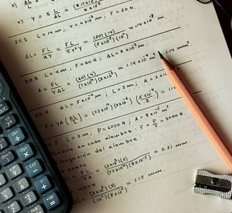 a calculator and a pencil and pencil on a notebook