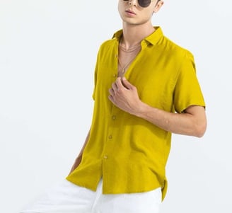 a man in a yellow shirt and white pants