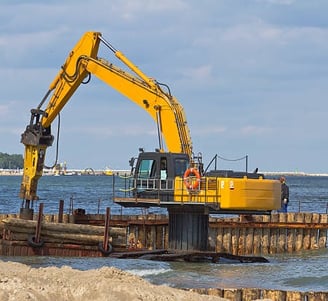 excavator holding logs for dock construction