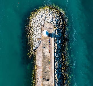 outcropped peninsula seawall with lighthouse aerial view