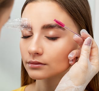 Esthetician performing eyebrow lamination