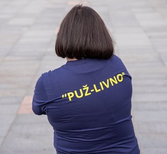 a woman in a blue shirt is holding a cell phone