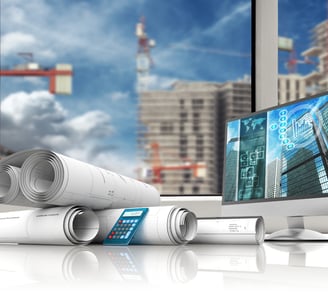 um computador e um projeto de construção na mesa