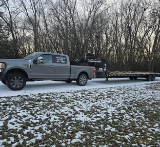 a truck with a flat bed and a flat bed, driving on snow