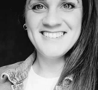 black and white photo of a woman's face with her hair down to one side and smiling