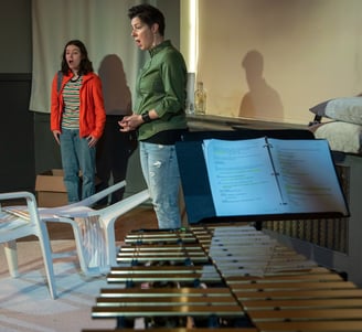 A preteen and her mom stand with their mouths hanging open, in the foreground we see a vibraphone.