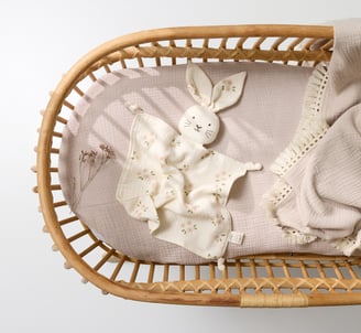 Product photography - a baby's cradler with a blanket and a bunny