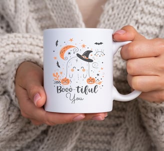 a person holding a mug with a halloween themed mug