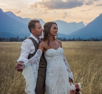 a bride and groom standing in a field in Yoho provincial park