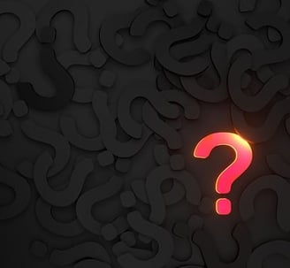 background of black question marks with single pink/ gold question mark in foregrounda question mark