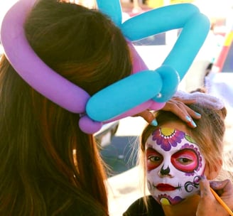 Caroline Face Painting a Sugar Skull for Day of the Dead Event