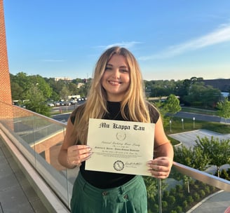 A young woman holding a certificate