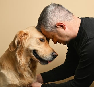 a man is petting a golden retriever