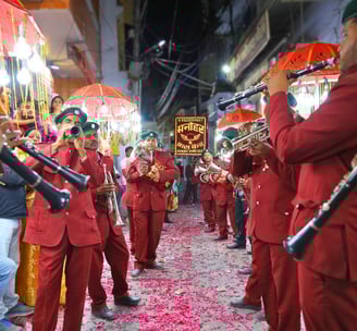 Manohar Brass Band, dressed in their traditional maroon attire and with all instruments, performing on the streets of Ajmer.