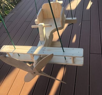a wooden airplane toy with a wooden swing