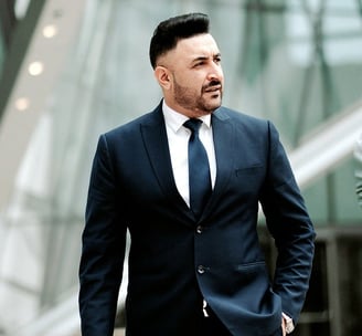 a man in a suit and tie walking down a sidewalk