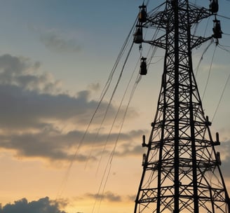 A counter with the name 'Janji Jiwa' above it, featuring a wooden panel design. Two people are behind the counter; they appear to work there. To the left, there are promotional posters, including one advertising a 10% cashback offer with GoPay. There are hanging lights and green plants adding to the decor.