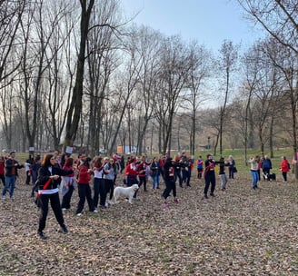 a group of people standing in a field with trees