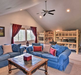 Upstairs loft with bunk beds, blue sofas, and large windows.