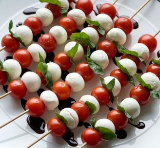 a plate of mozzarella tomatoes and mozzarella cheese skewers