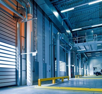 a truck parked in a warehouse with a truck parked in front of it