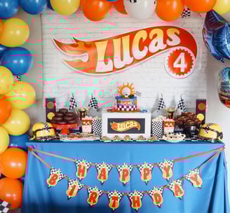 a birthday party table with a cake and balloons