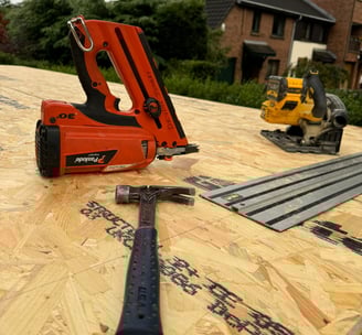 Image showing nail gun and hammer on top of garage roof being renovated