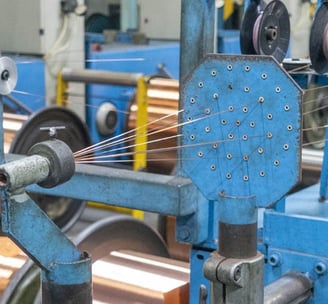 a machine is spinning a coil of copper foil