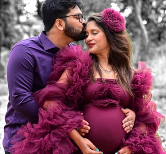 a pregnant woman and her husband are posing for a photo