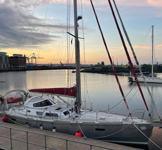 a sailboat docked at a dock with a sunset