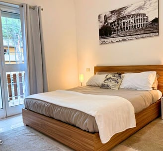 a bedroom with a bed and a balcony air conditioner