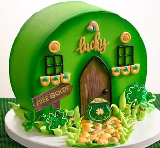 a cake with a green and white house with shamrocks