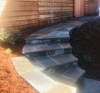 a stone stepstone with a stone steps leading up to a house