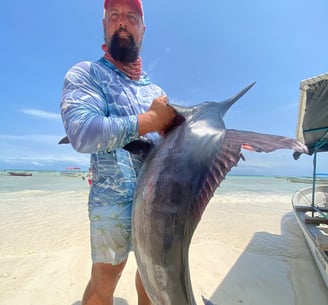 Angler with a black marlin caught on a Zanzibar Catamaran Fishing Charter