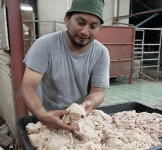 a man in a green hat and a pile of cow intestines