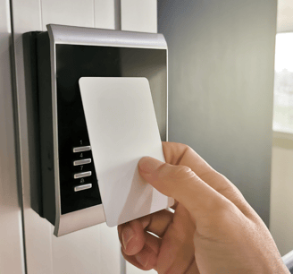 a person holding a card and pressing a button on a door