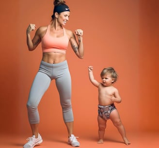 a woman in a sports brailler and a baby in a diaper