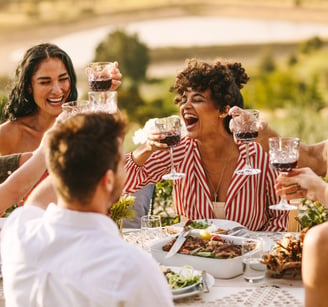 a group of people sitting around a table with wine glasses