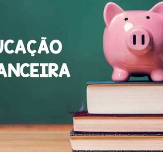 Um cofrinho no formato de um porquinho cor de rosa sobre livros e ao fundo um quadro negro de escola