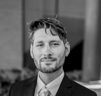 a man in a suit and tie standing in front of a building