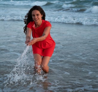 a woman in a red dress is playing with a frisbee