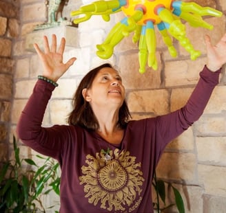 a woman holding a balloon - shaped like a sunflower