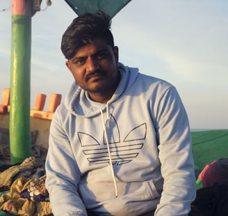 a man sitting on a blanket in a tent